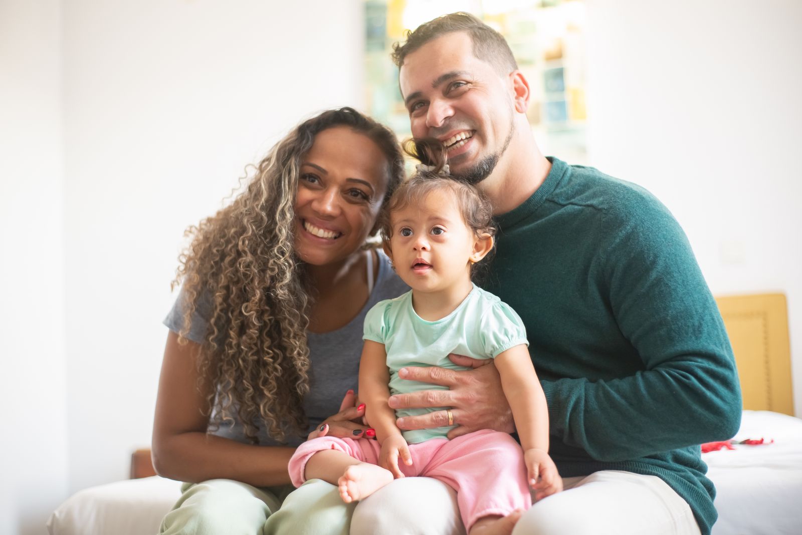 Two parents smiling with their young child
